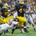 Michigan running back De'Veon Smith is tripped up Central Michigan Dennis Nalor during the forth quarter of their game, Saturday Aug, 31. 